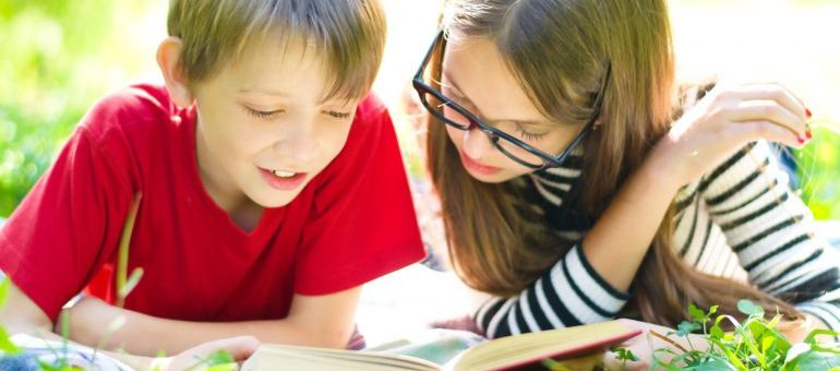 Children reading books on the grass